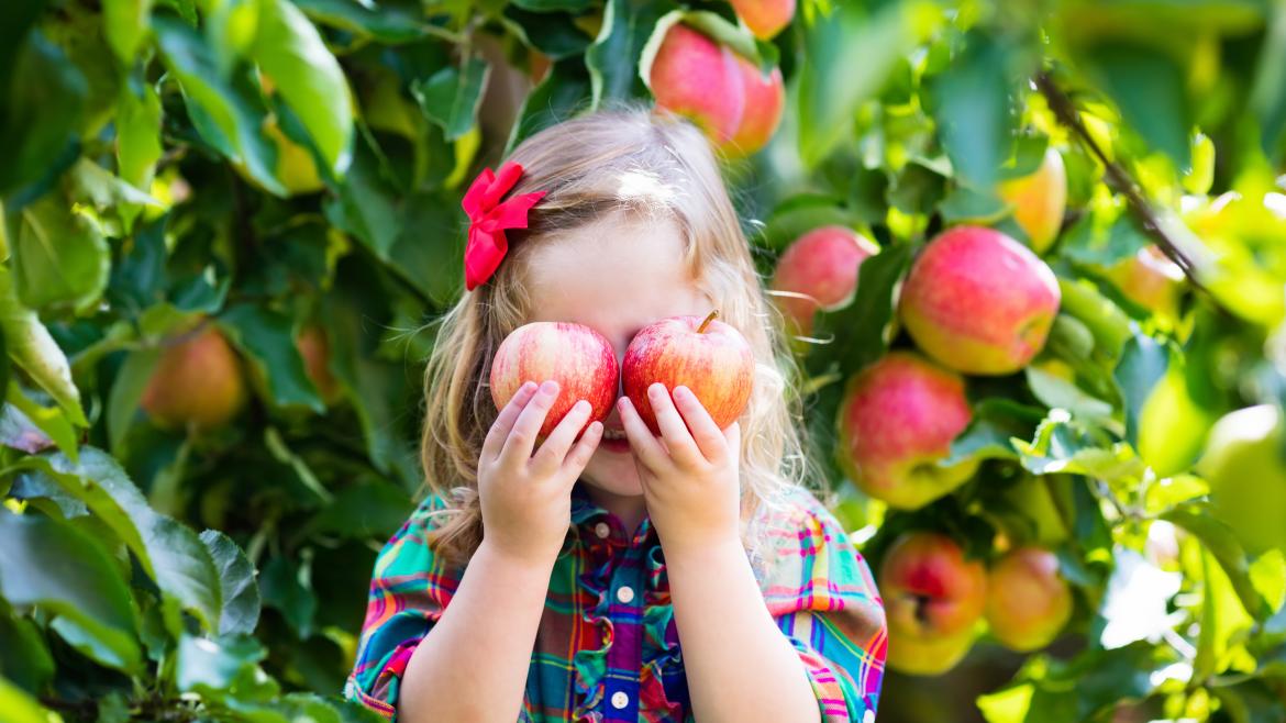 Kind hält sich zwei Äpfel vor die Augen